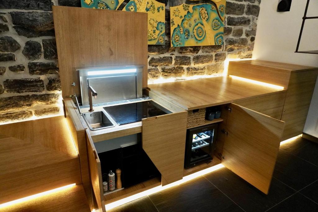 Elle comprend une petite cuisine avec des placards en bois et un évier. dans l'établissement Capitolare Suite Tower, à Portovenere 39 autres photos