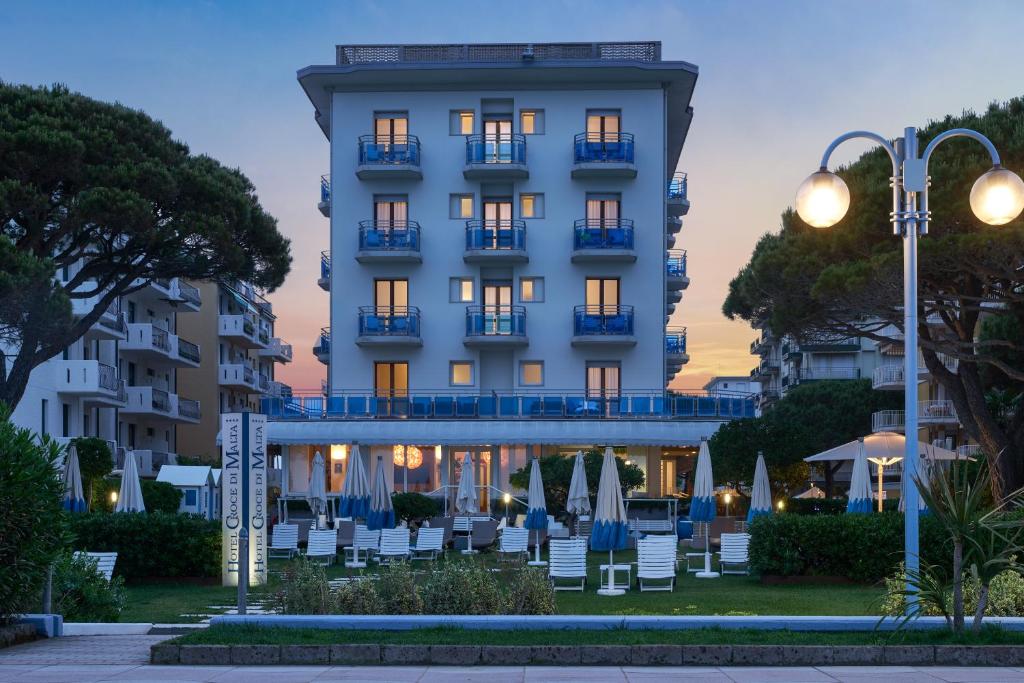 un hôtel avec des chaises en face d'un bâtiment dans l'établissement Hotel Croce Di Malta, à Lido di Jesolo