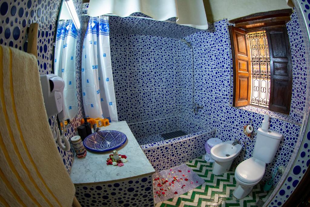 La salle de bains est pourvue de carrelage bleu et blanc. dans l'établissement Riad LalaMoune, à Fès