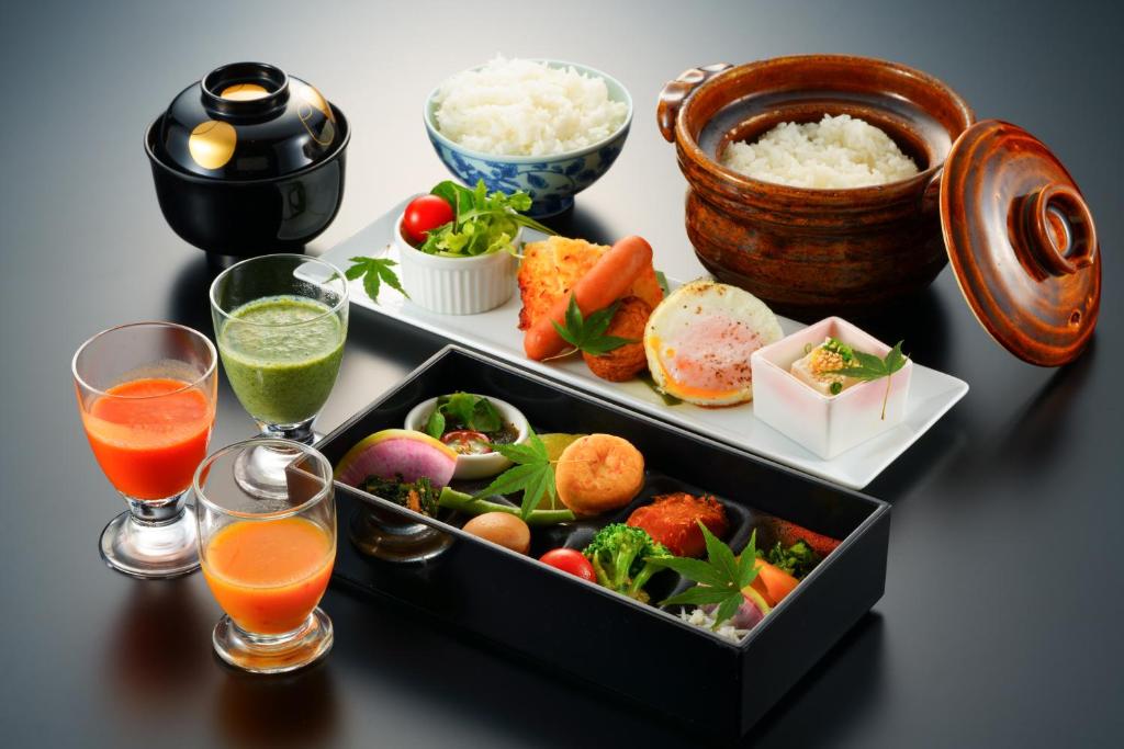 - une table avec un plateau de nourriture et 2 verres de jus dans l'établissement Beppu Fuga, à Beppu 30 autres photos