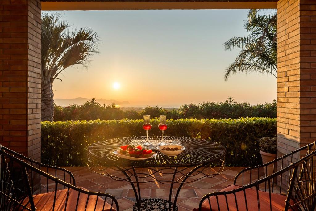 une terrasse avec une table et deux verres de vin dans l'établissement Cleo - Villa Siciliana, à Partinico
