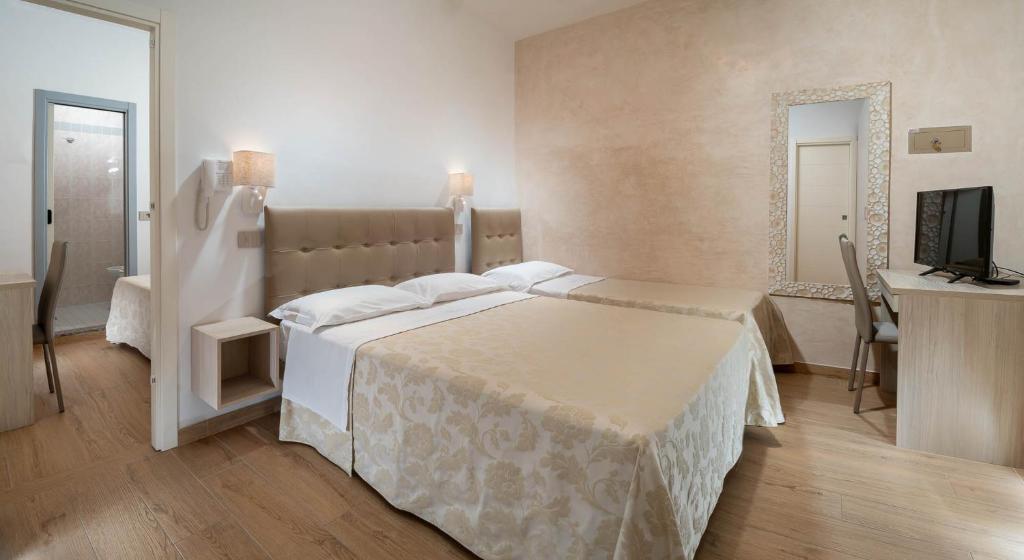 une chambre d'hôtel avec deux lits et une télévision dans l'établissement Hotel Novella, à Misano Adriatico