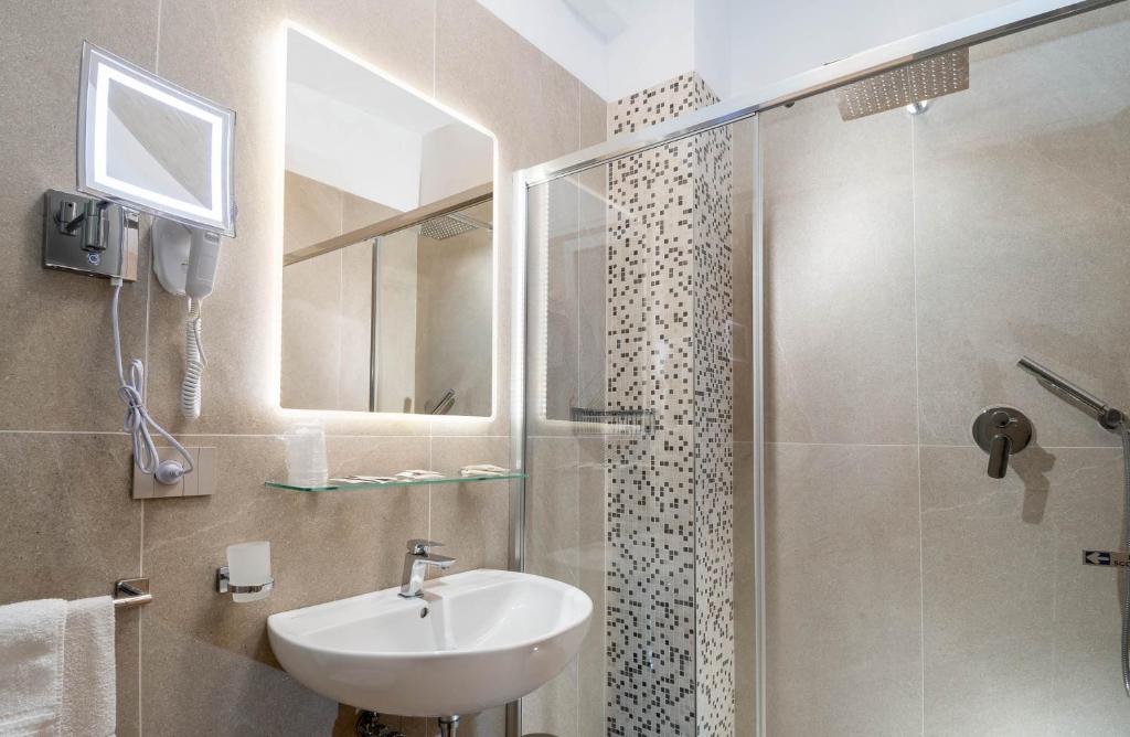 une salle de bain avec un lavabo et une douche dans l'établissement Hotel Novella, à Misano Adriatico
