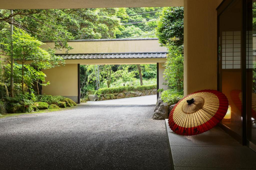 un parapluie rouge assis sur le côté d'un bâtiment dans l'établissement Oku Yugawara SANSUIROU, à Yugawara