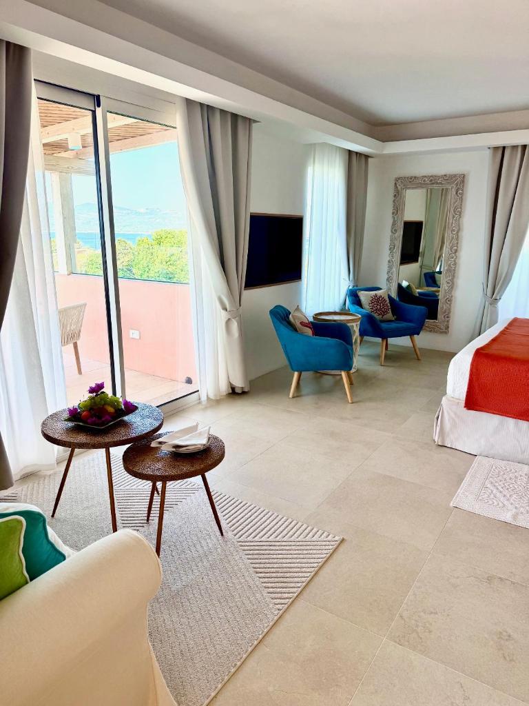 une chambre d'hôtel avec un lit et une grande fenêtre dans l'établissement Hotel Capriccioli, à Porto Cervo