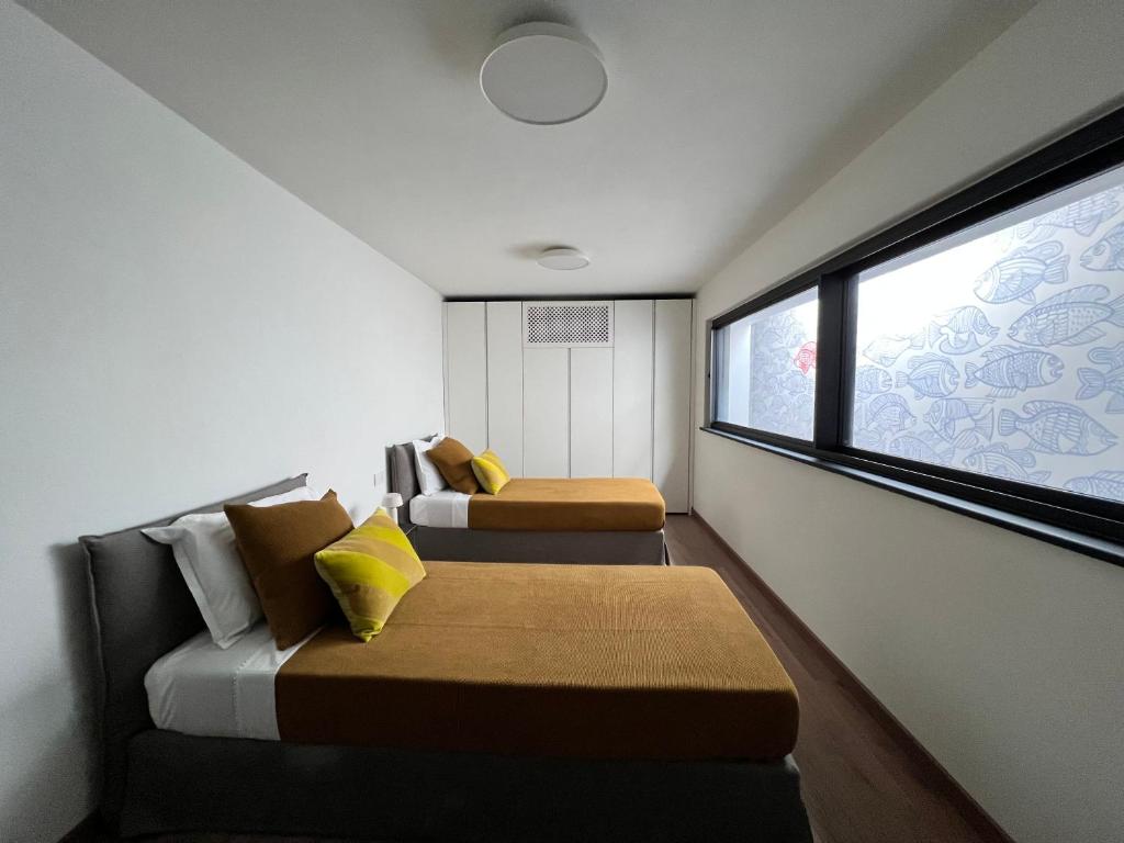 deux lits dans une petite pièce avec une fenêtre dans l'établissement Villa al Cio, Bonassola, à Bonassola