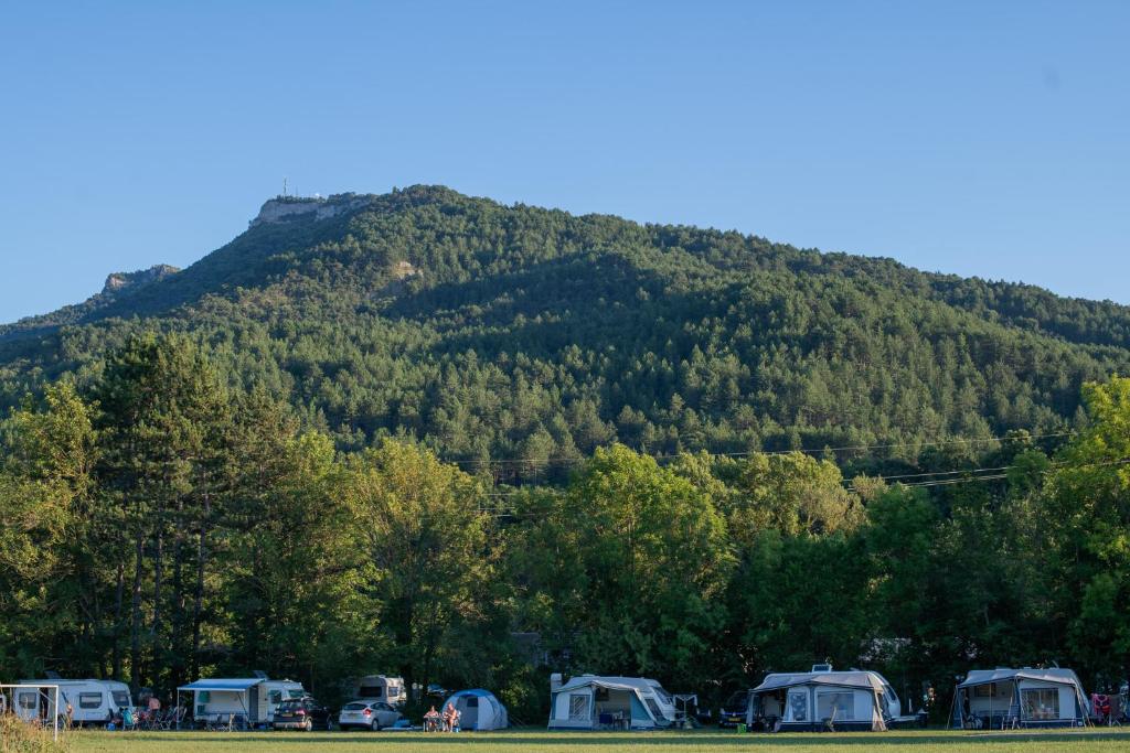 un groupe de tentes devant une montagne dans l'établissement Camping Onlycamp De Chamarges, à Die