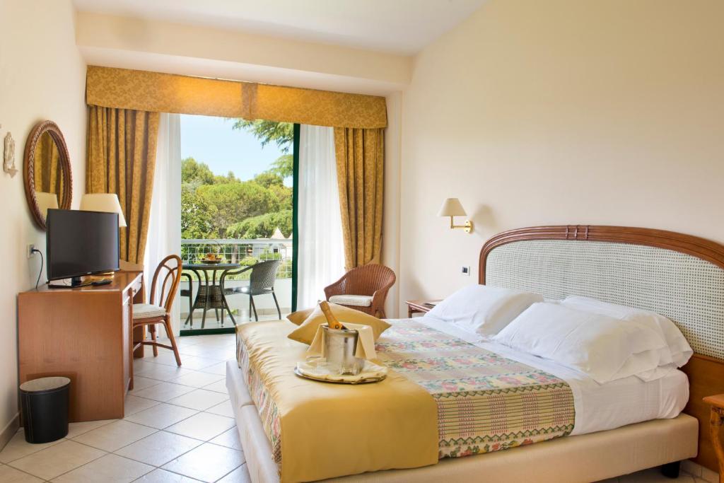 une chambre d'hôtel avec un lit et un balcon dans l'établissement Hotel Sierra Silvana, à Selva di Fasano