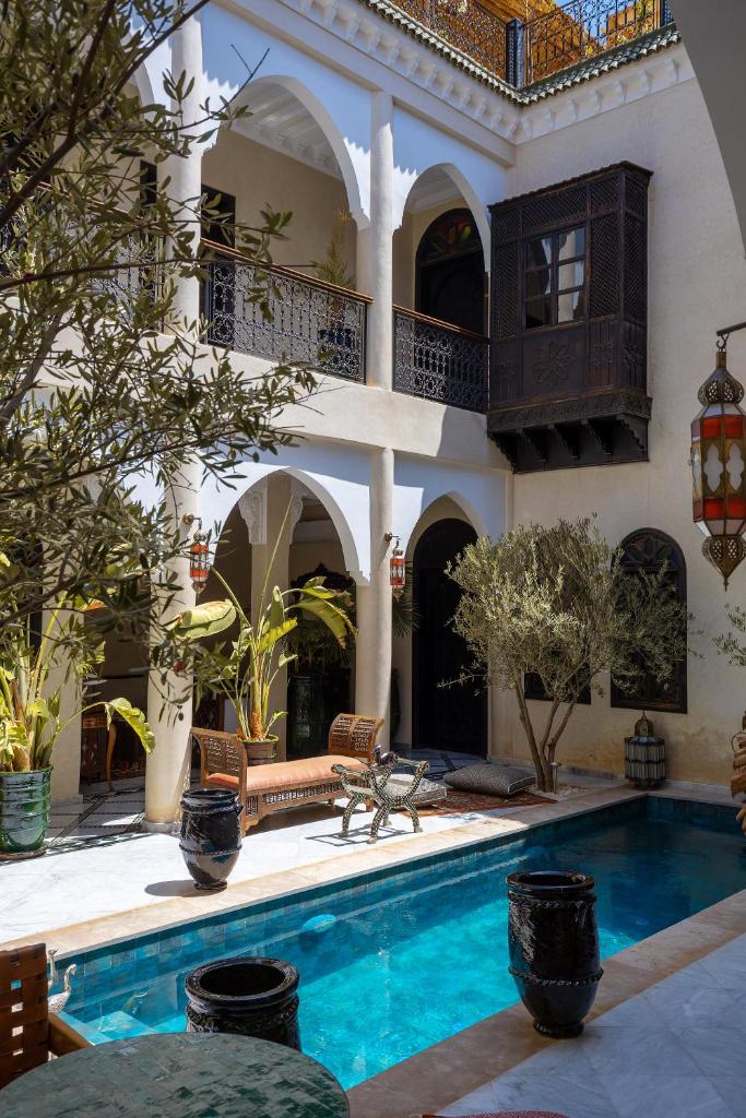 une maison avec une piscine devant dans l'établissement Alrashid Marrakech - Hotel & SPA, à Marrakech