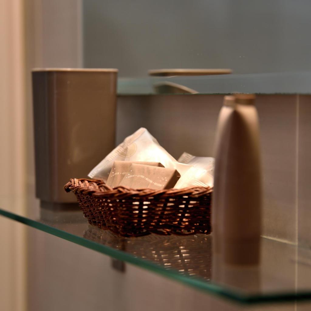 un panier sur une étagère en verre avec un vase dans l'établissement Hotel Alaska, à Rimini