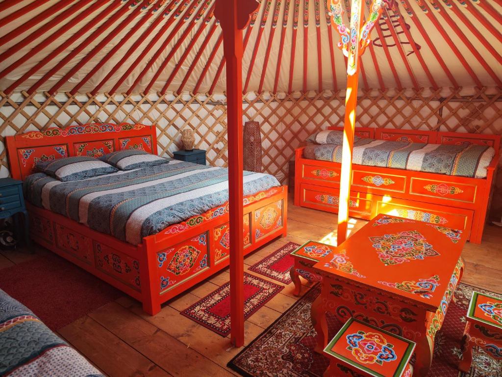 - une chambre avec 2 lits et une table dans une yourte dans l'établissement Yourte traditionnelle mongole, à Marcoux