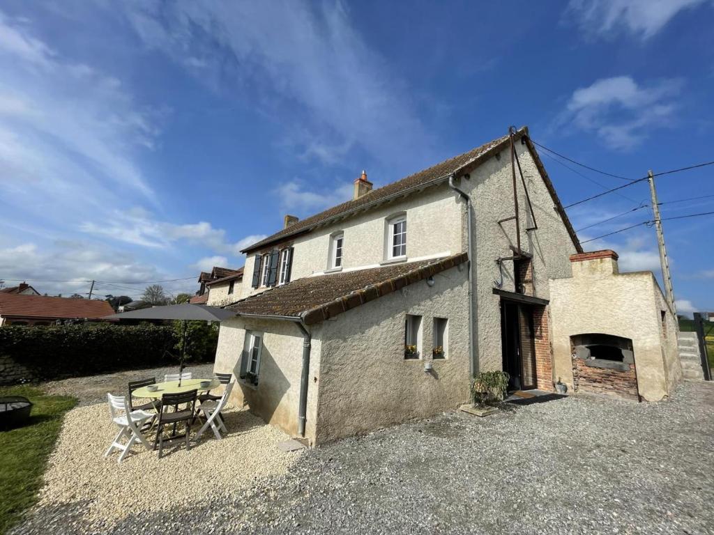 Cette petite maison dispose d'une table et d'une terrasse. dans l'établissement Gîte Contemporain pour 4 avec Piscine Chauffée et Bureau à Proximité des Sites Historiques - FR-1-489-444, à Louchy-Montfand