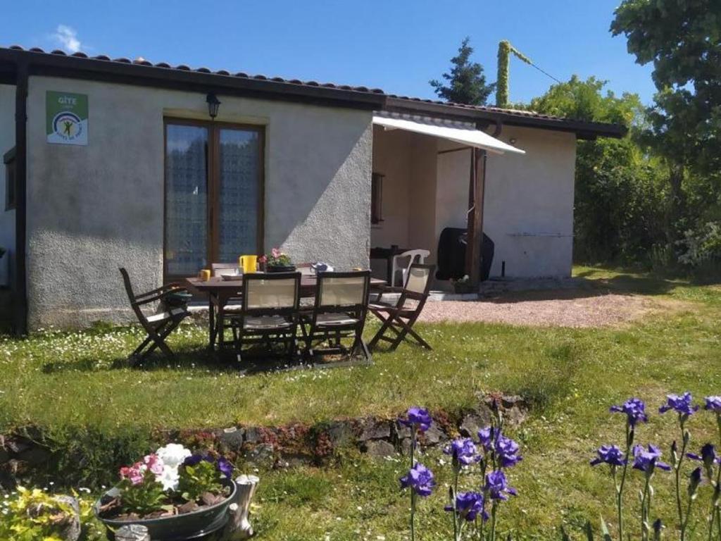 une table et des chaises devant une maison dans l'établissement Gîte familial avec piscine, jardin clos et jeux pour enfants - Saint-Haon-le-Châtel - FR-1-496-21, à Saint-Haon-le-Châtel