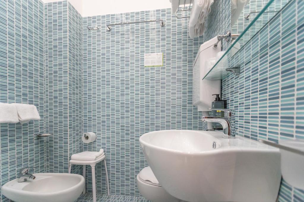 une salle de bain avec un lavabo blanc et des toilettes dans l'établissement Club Hotel, à Riccione