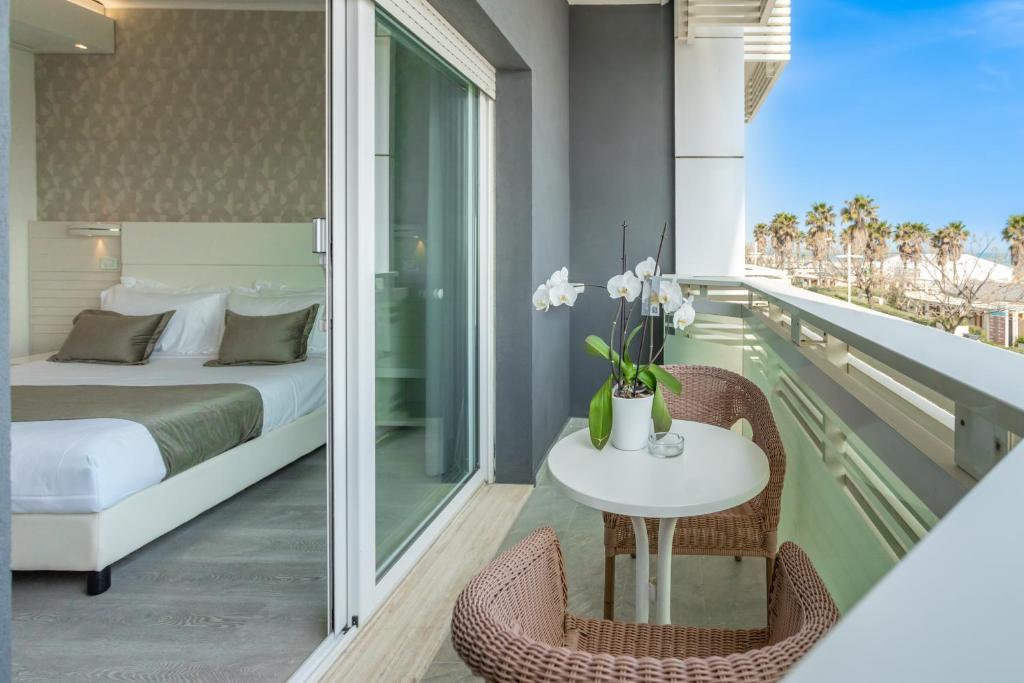 - une chambre avec un lit et une table sur un balcon dans l'établissement Club Hotel, à Riccione