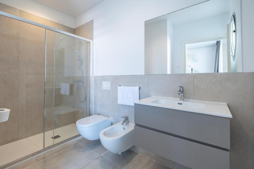 une salle de bain avec un lavabo, des toilettes et une douche dans l'établissement Residence Panorama Apart Hotel, à Bibione