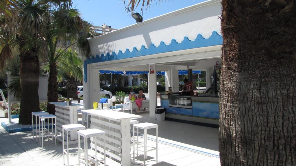 un bar avec tabourets devant un bâtiment dans l'établissement Hotel Lanterna, à Porto San Giorgio