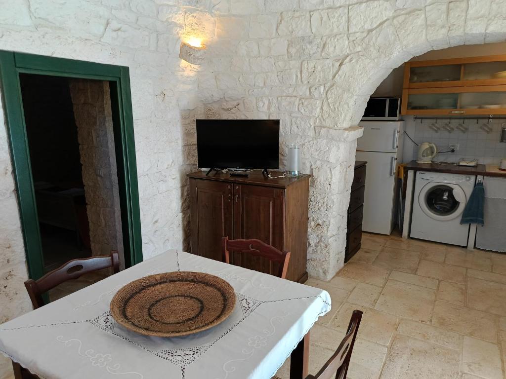 d'une salle à manger avec une table et d'une cuisine avec une télévision. dans l'établissement Villa Trullo Panorama, à Locorotondo