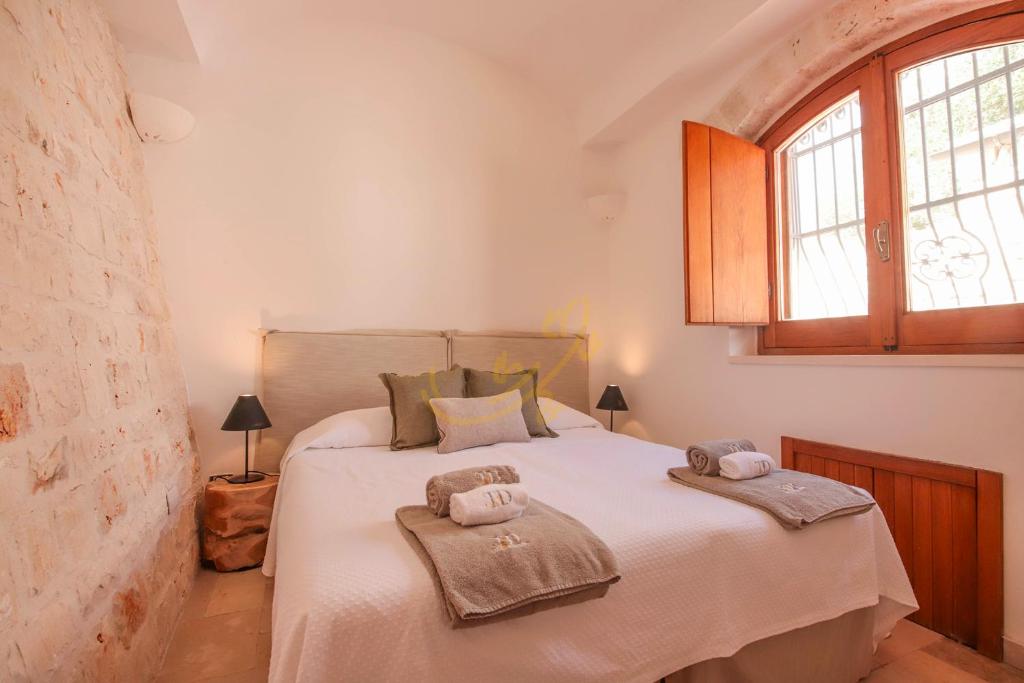 une chambre avec un lit avec deux serviettes dessus dans l'établissement TD Trulli Altura with Pool & Stunning Sunsets, à Martina Franca