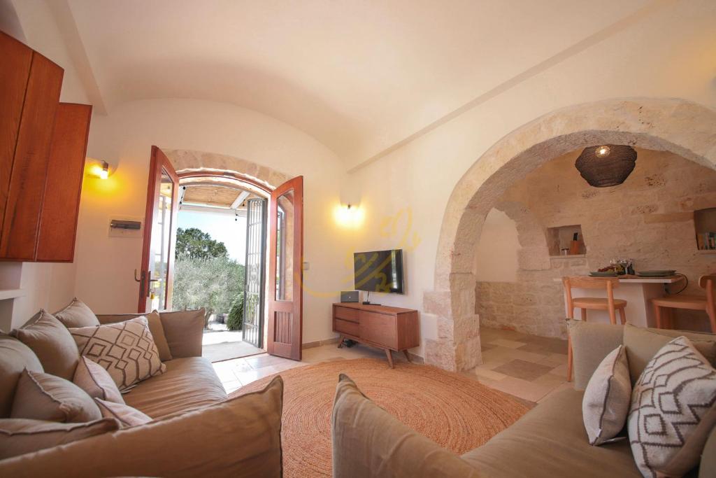 - un salon avec un canapé et une voûte dans l'établissement TD Trulli Altura with Pool & Stunning Sunsets, à Martina Franca