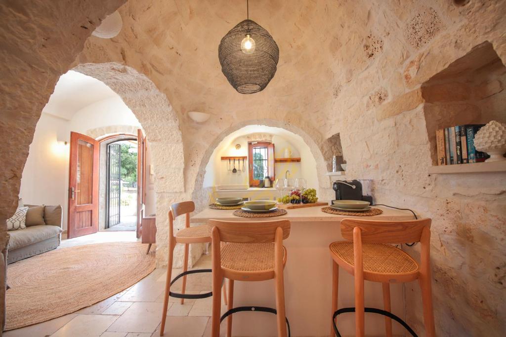 une cuisine avec une table et des chaises dans une pièce dans l'établissement TD Trulli Altura with Pool & Stunning Sunsets, à Martina Franca