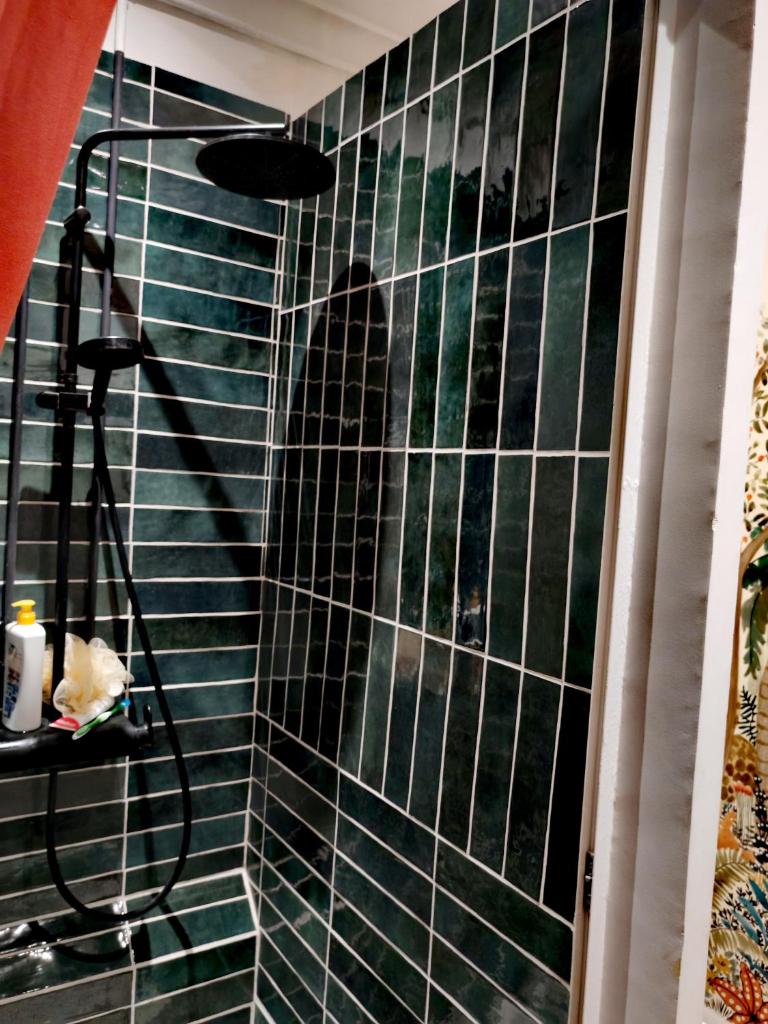 une cabine de douche avec un mur carrelé noir dans l'établissement Tente mongole 4 saisons cosy et spacieux, à Conchy-les-Pots