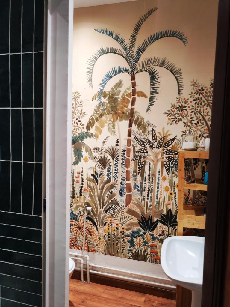 La salle de bains est pourvue d'une fresque murale représentant des palmiers. dans l'établissement Tente mongole 4 saisons cosy et spacieux, à Conchy-les-Pots