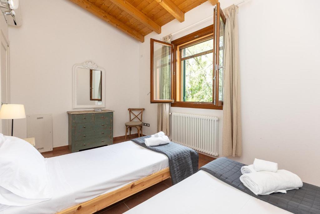 une chambre avec deux lits et une fenêtre dans l'établissement Villa Saturnia - Piscina Privata - 9' dalle Terme, à Capanne 64 autres photos