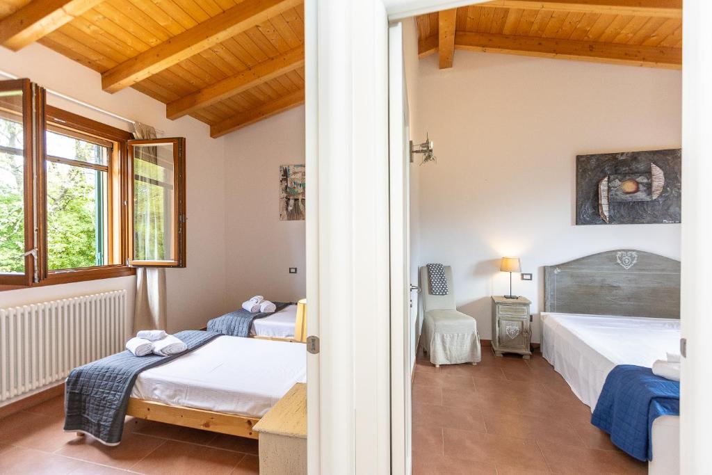 une chambre avec deux lits et une fenêtre dans l'établissement Villa Saturnia - Piscina Privata - 9' dalle Terme, à Capanne