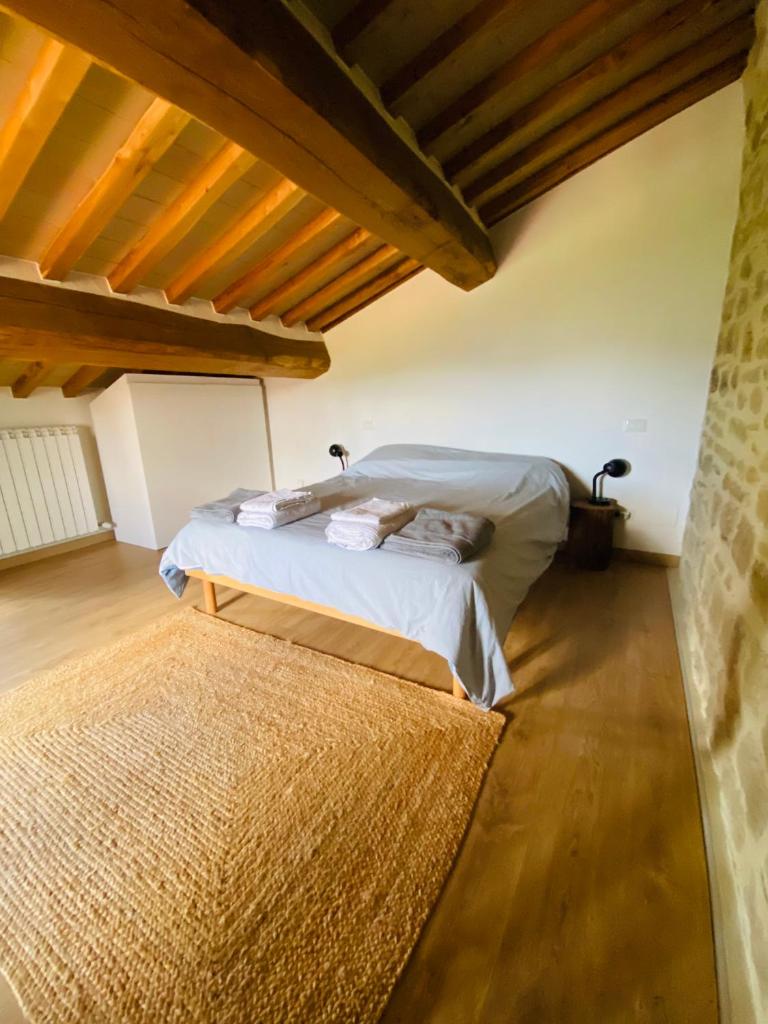 une chambre avec un lit dans une pièce avec des plafonds en bois dans l'établissement Villa Angela - Ranza 55, à Lugnano 41 autres photos
