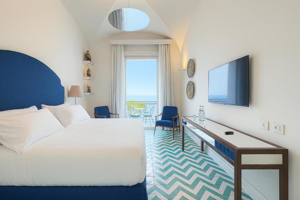 une chambre avec un lit, un bureau et une télévision dans l'établissement Grand Hotel Europa Palace Sorrento, à Sorrente