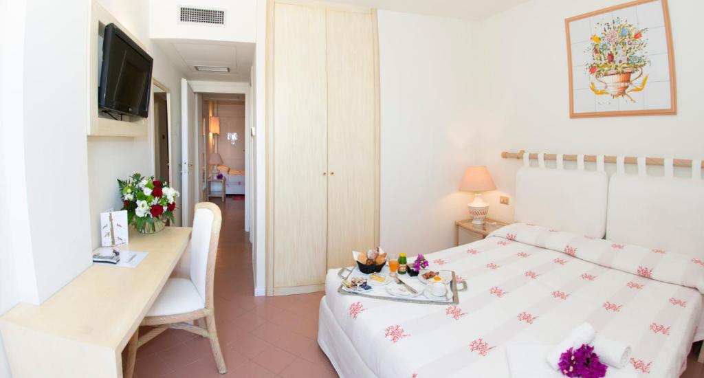 une chambre avec un lit, une table et un bureau dans l'établissement Hotel Palau, à Palau