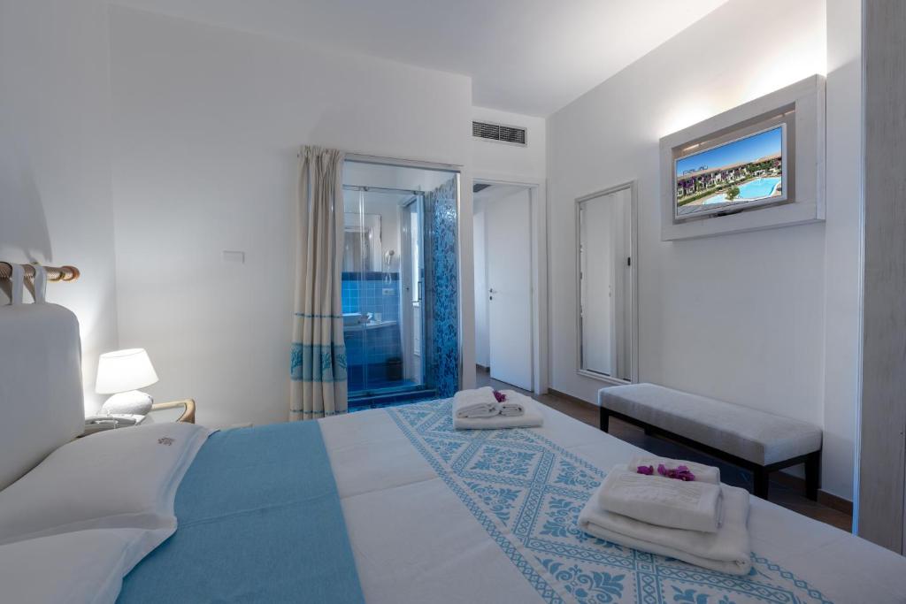 une chambre avec un lit avec deux serviettes dessus dans l'établissement Hotel Palau, à Palau