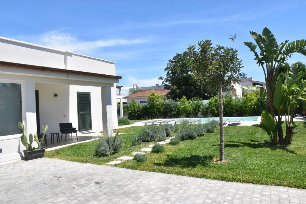 un jardin avec une piscine et une maison dans l'établissement Casa del Sol Luxury Estate Puglia, à Leporano Marina
