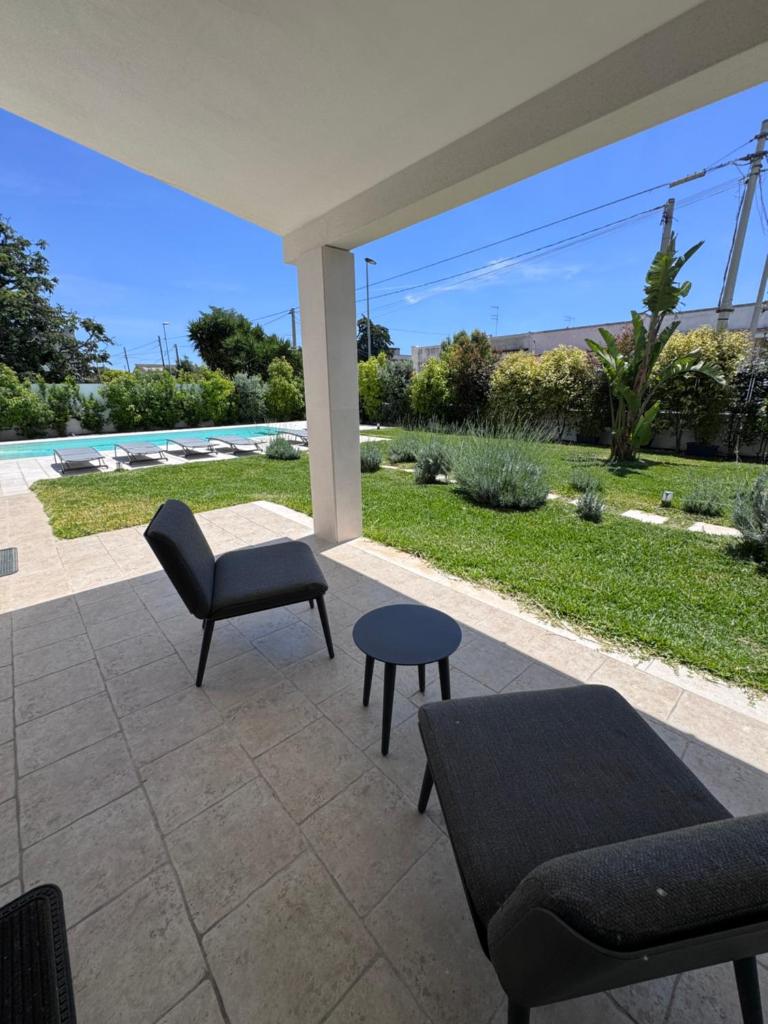 une terrasse avec un canapé, une chaise et une table dans l'établissement Casa del Sol Luxury Estate Puglia, à Leporano Marina