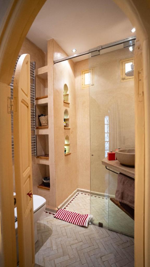 une salle de bain avec une douche en verre et des toilettes dans l'établissement Riad Anata, à Fès