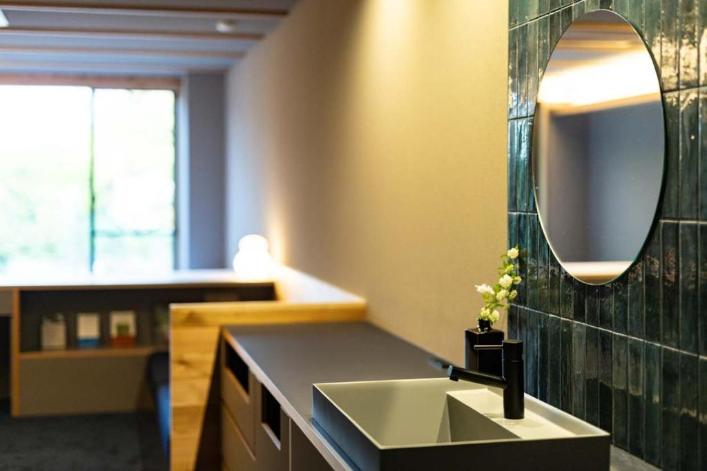 une salle de bain avec un lavabo et un miroir au mur dans l'établissement Hotel Park, à Gifu