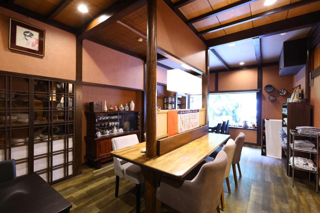 une salle à manger avec une table et des chaises en bois dans l'établissement Ikariya Ryokan, à Yamanouchi