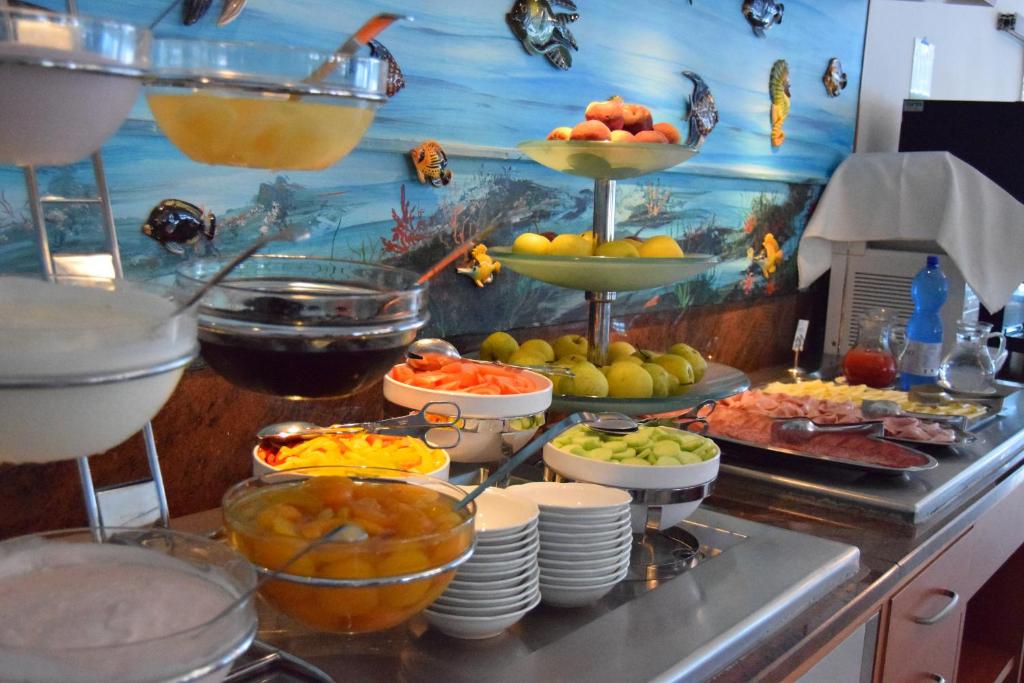un buffet avec de nombreux types de nourriture différents sur un comptoir dans l'établissement Hotel Vina De Mar, à Lignano Sabbiadoro