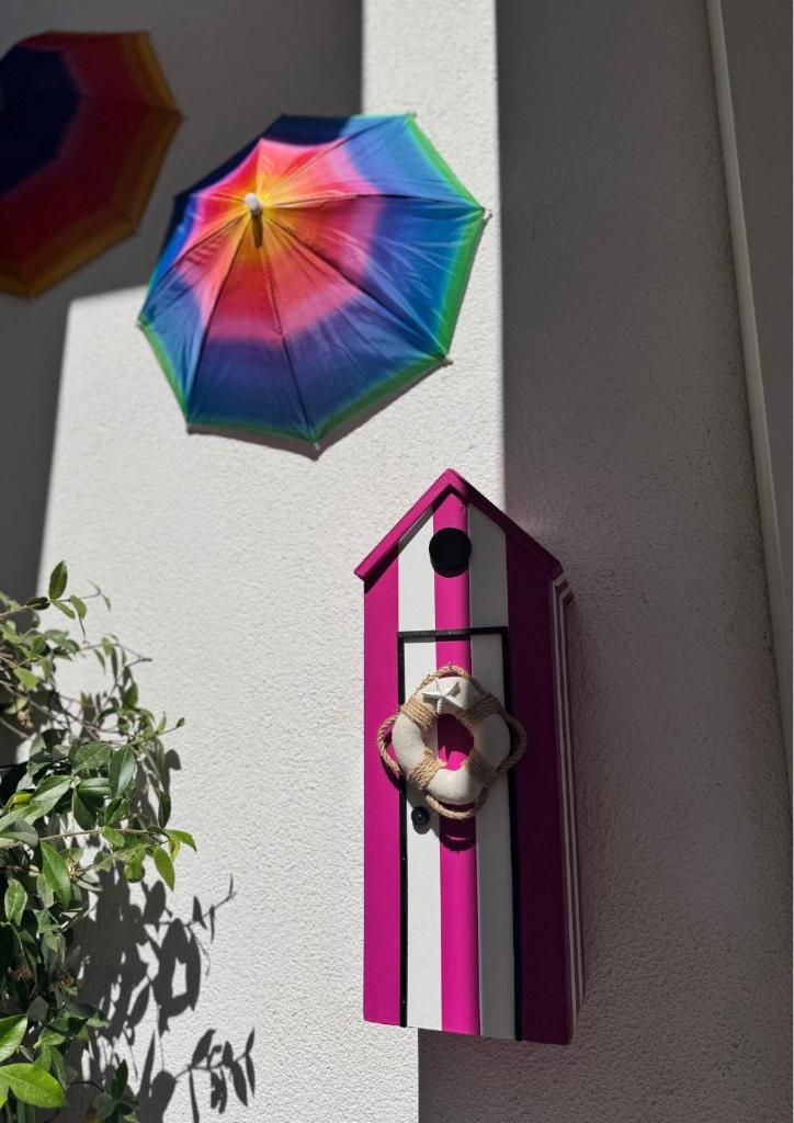 un parapluie coloré dans un nichoir sur un mur dans l'établissement Regina Urban Beach Hotel, à Lido di Jesolo