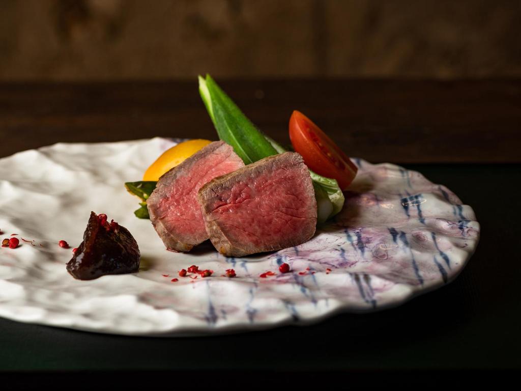 une plaque de nourriture contenant de la viande et des légumes dans l'établissement TSUCHIYA Kinosaki onsen, à Toyooka