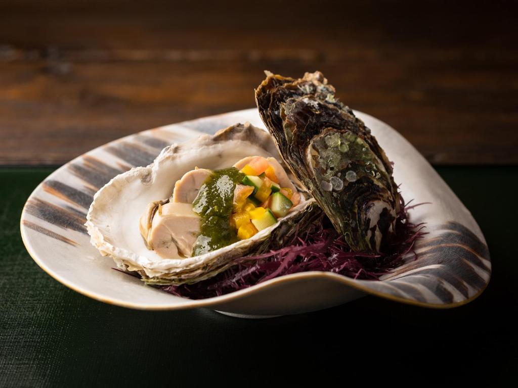 une plaque de nourriture avec une coquille sur une table dans l'établissement TSUCHIYA Kinosaki onsen, à Toyooka