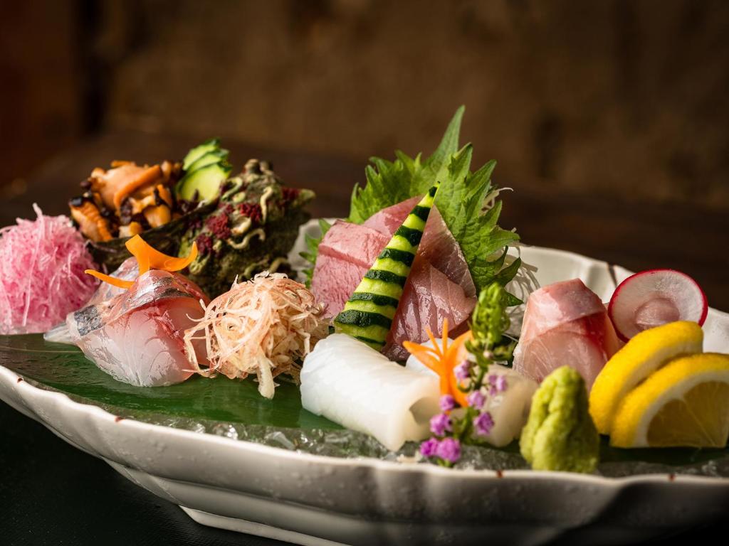 une assiette de nourriture assise sur une table dans l'établissement TSUCHIYA Kinosaki onsen, à Toyooka