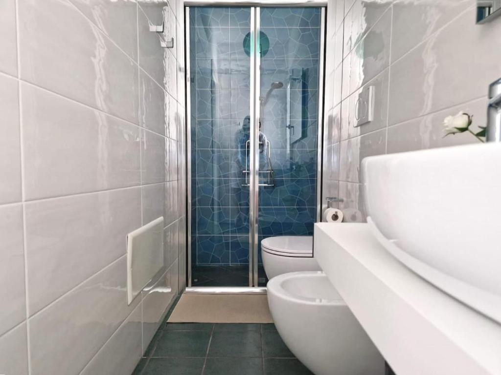 une salle de bain avec toilettes et douche en verre dans l'établissement Villa Livio, à San Pietro in Bevagna