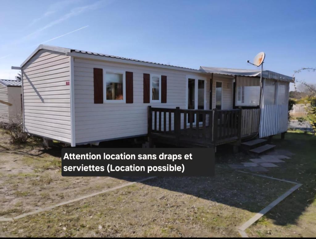 une petite maison blanche avec un panneau indiquant « Attention, localisation, effets du SRAS » lors des services dans l'établissement Bungalows soit en 3 ou 4ch - 2 à 10 places - mh732 3ch ou mh828 4ch océan proche Biscarrosse, à Gastes