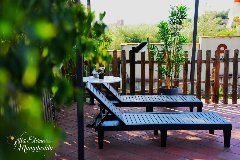 un banc et une table sur une terrasse dans l'établissement Villa Eterna Mungibeddu, à Paterno
