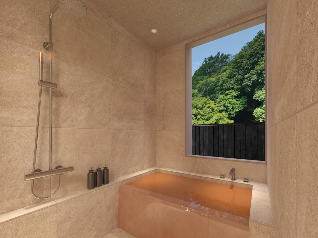 La grande salle de bains est pourvue d'une baignoire et d'une fenêtre. dans l'établissement KAMENOI HOTEL Arima, à Kobe