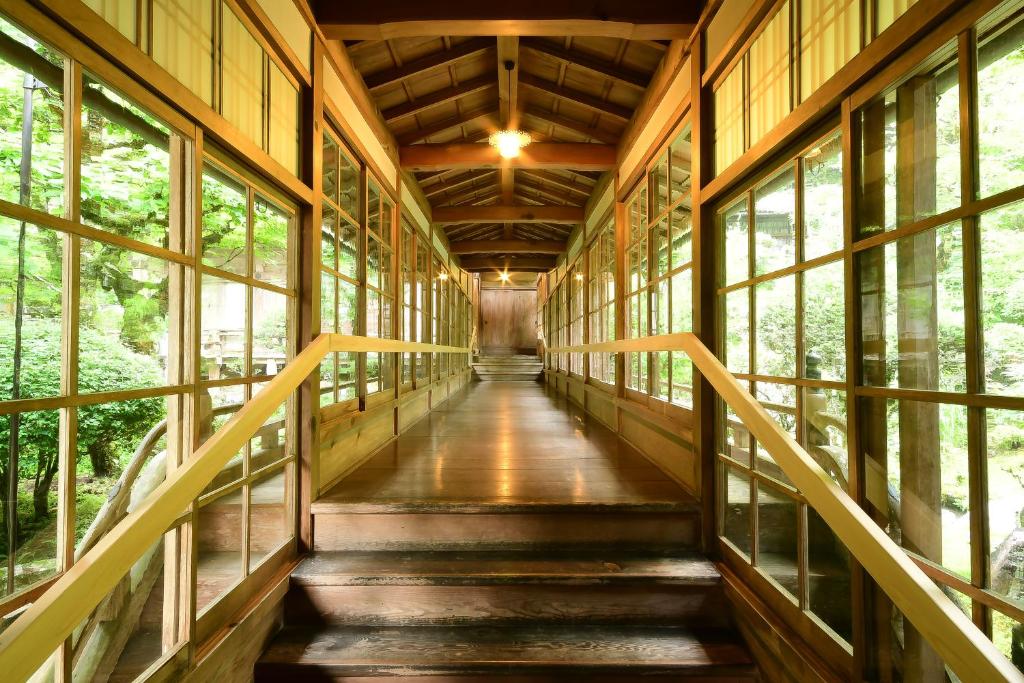 - un couloir dans un bâtiment en bois avec des fenêtres dans l'établissement Kongo Sanmaiin, à Koyasan