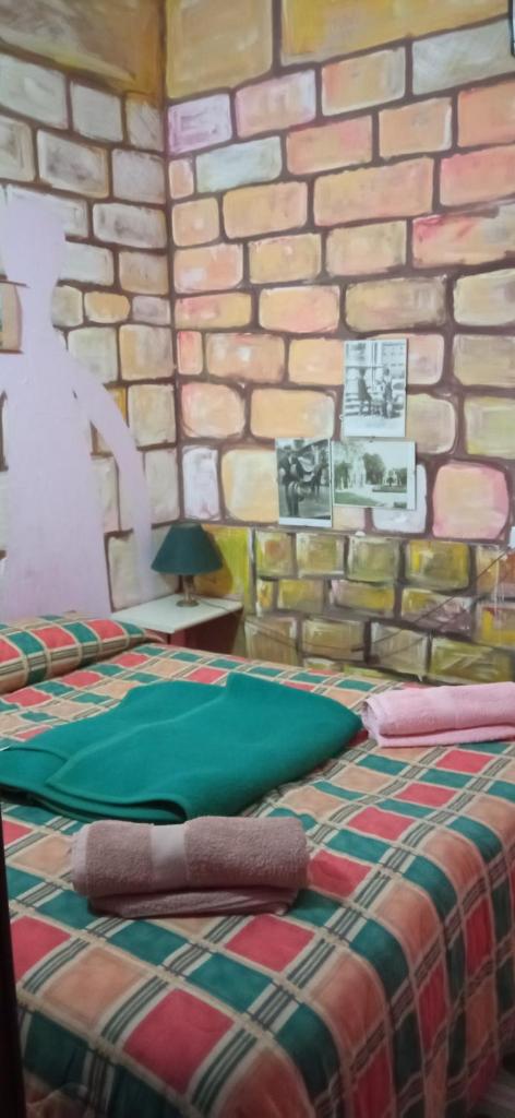 Cette chambre dispose de 2 lits en face d'un mur en pierre. dans l'établissement natura e relax sul mare, à Gela