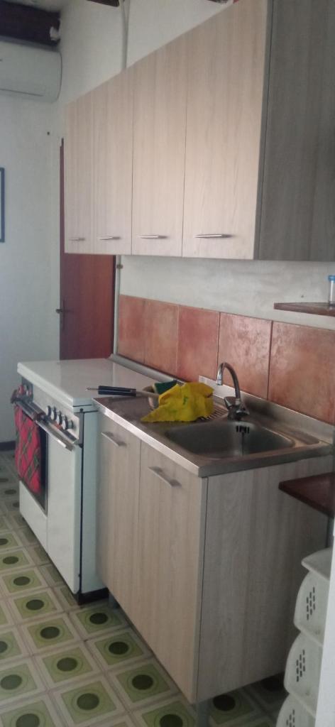 une cuisine avec un évier et une cuisinière dans l'établissement natura e relax sul mare, à Gela